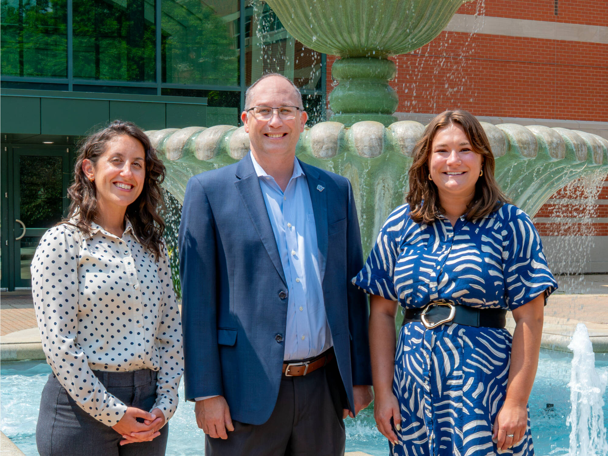 Team of SASC Success Coaches standing outside by the Student Services Building in front of the fountain